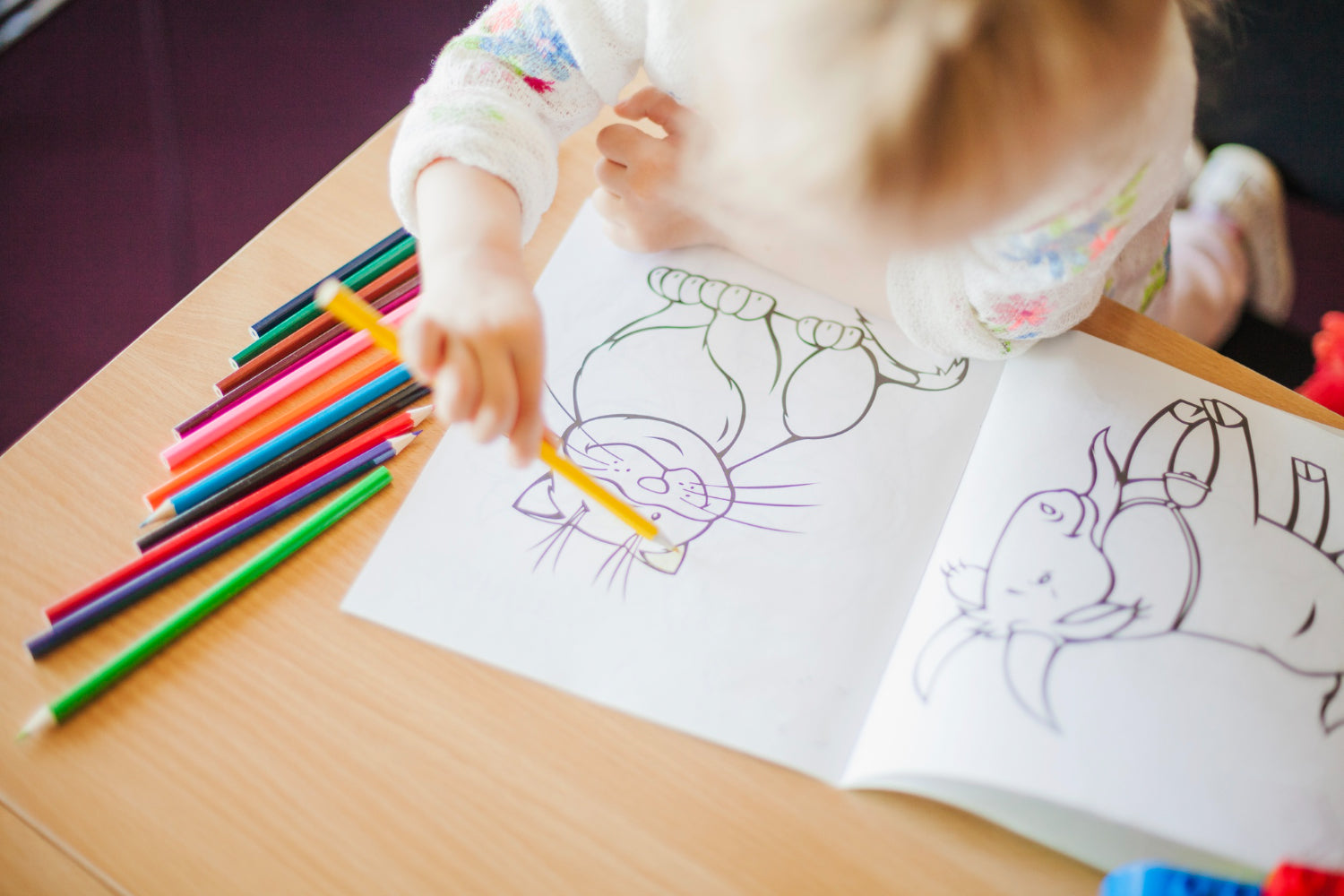 Photo of girl using a children's colouring book