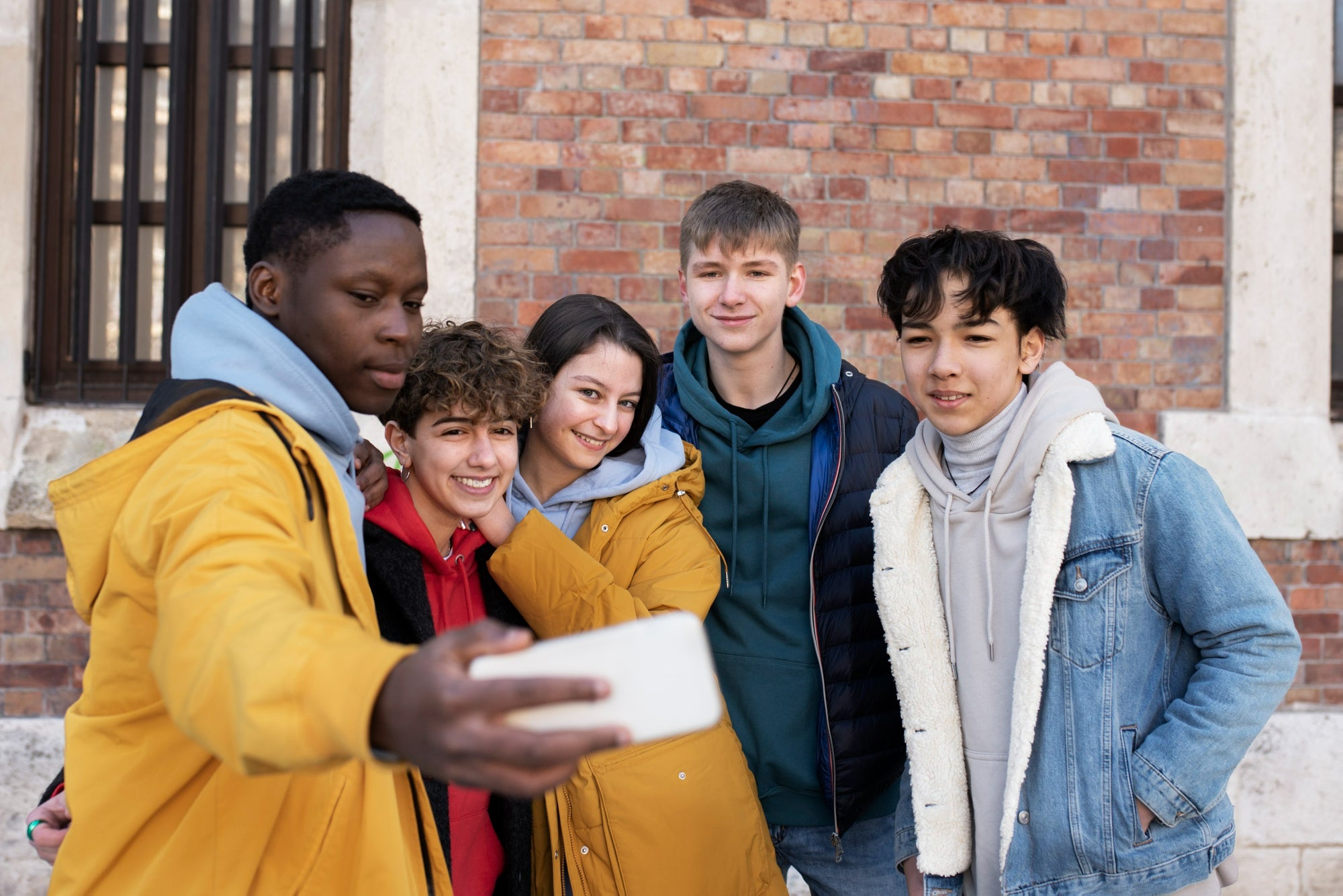 Photo of youths looking at phone to illustrate a blog on youth emotional support
