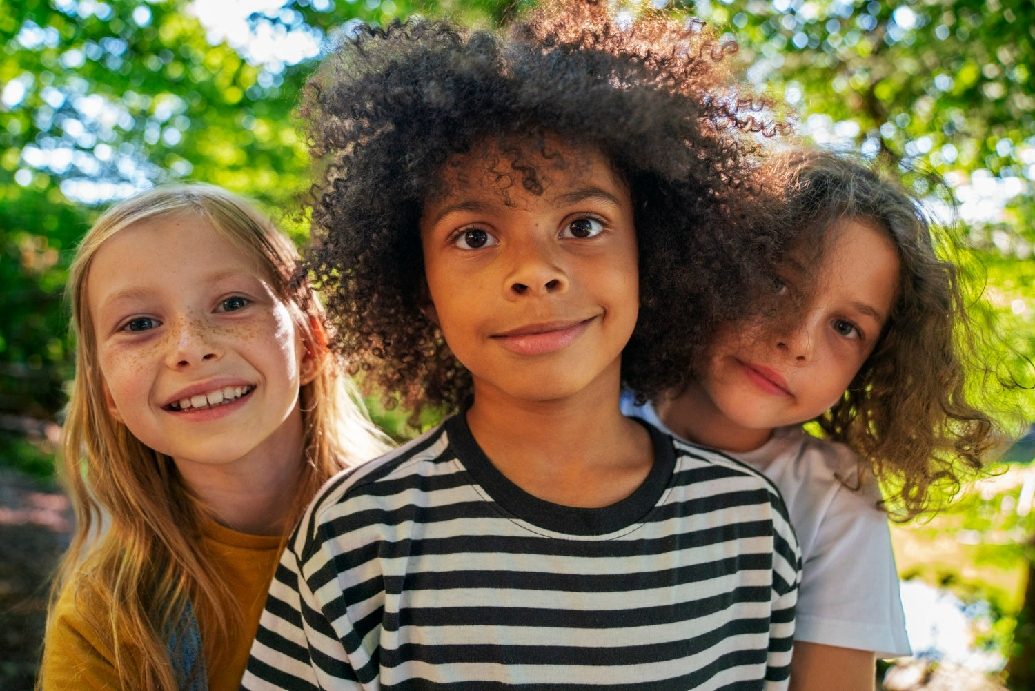Photo of three children looking happy outside to illustrate youth emotional support
