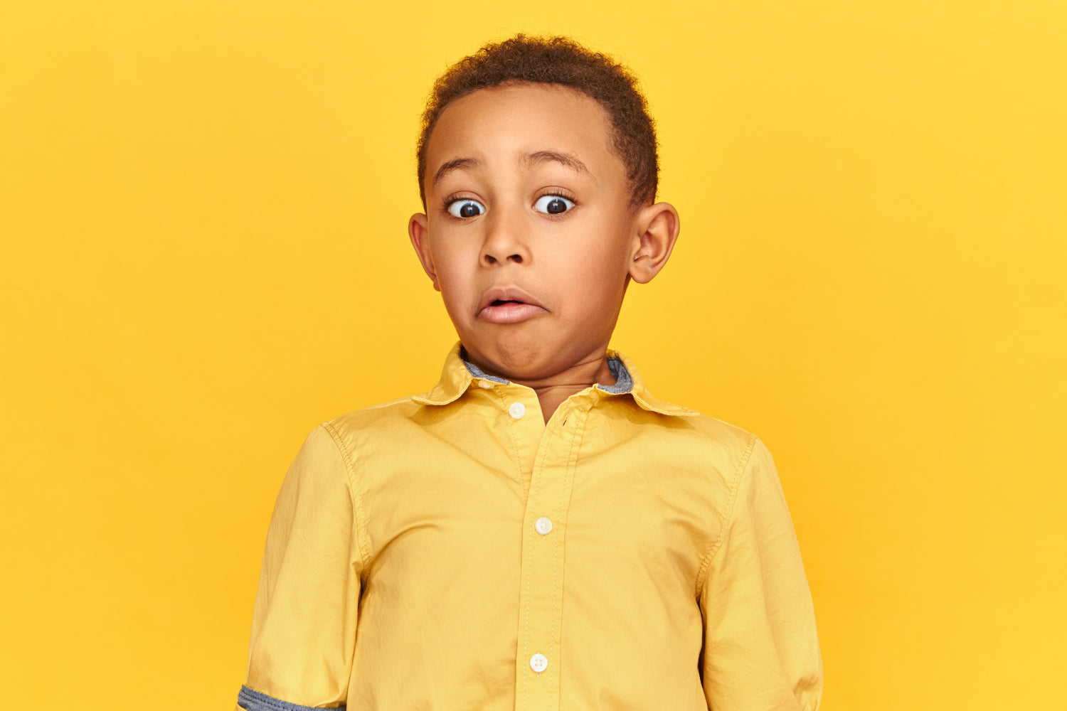 Picture of child on yellow background looking surprised to illustrate online resources for youth emotional support